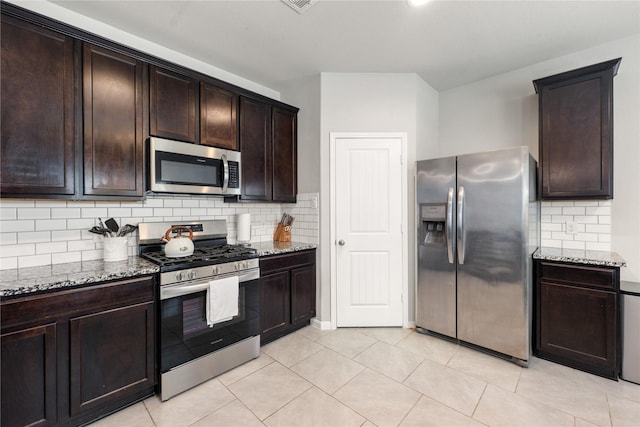 kitchen featuring light stone counters, backsplash, and appliances with stainless steel finishes