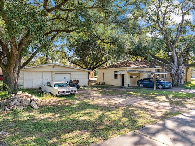 view of front facade with a front yard, a garage, and an outdoor structure