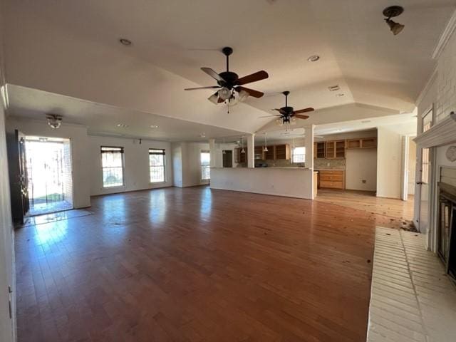 unfurnished living room with a fireplace, hardwood / wood-style flooring, vaulted ceiling, and ceiling fan