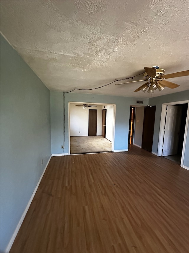 empty room with ceiling fan, hardwood / wood-style flooring, and a textured ceiling