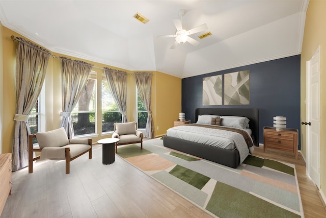 bedroom featuring light wood-type flooring, a tray ceiling, ceiling fan, and ornamental molding