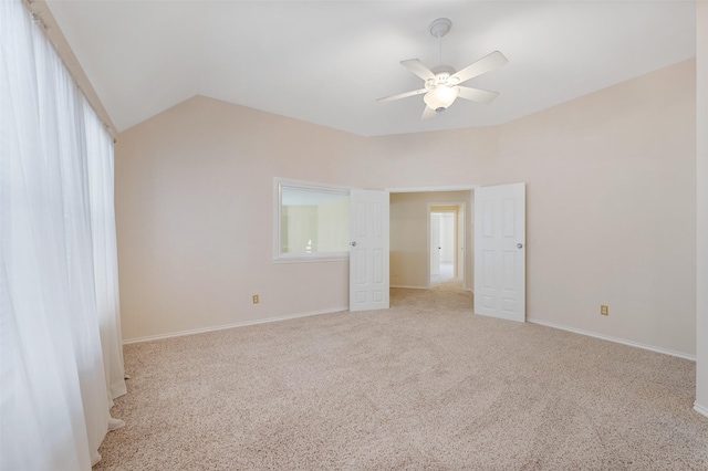 carpeted spare room featuring ceiling fan and lofted ceiling