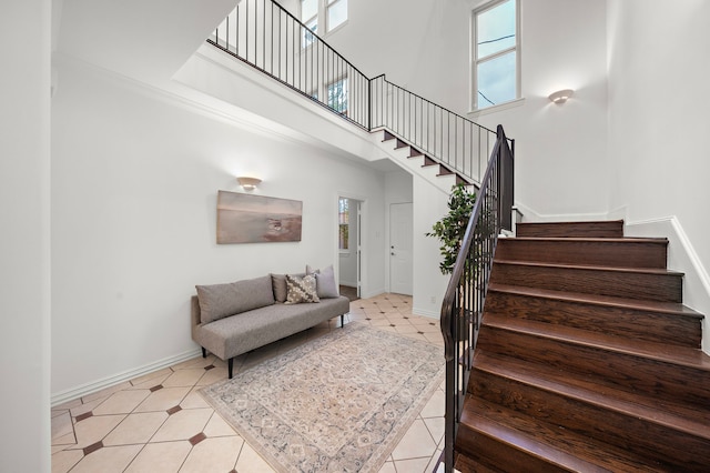 staircase with tile patterned flooring and a high ceiling