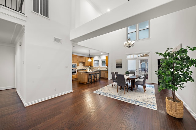 dining room with french doors, dark wood-type flooring, a high ceiling, and a chandelier