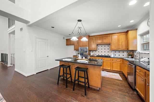 kitchen featuring appliances with stainless steel finishes, a kitchen breakfast bar, dark wood-type flooring, sink, and a kitchen island