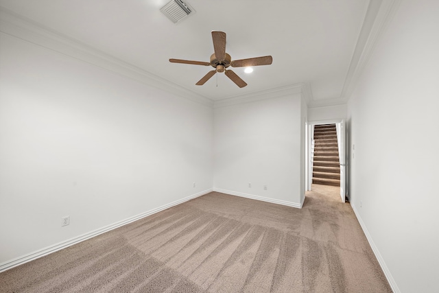 carpeted spare room with ceiling fan and ornamental molding