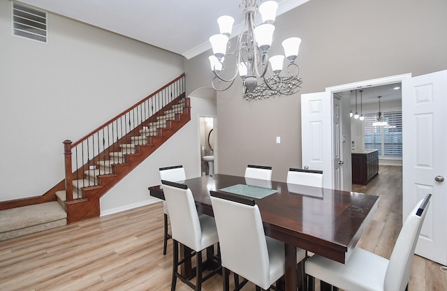 dining space with a chandelier, light hardwood / wood-style floors, and ornamental molding