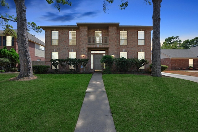 view of front of property with a yard and a balcony