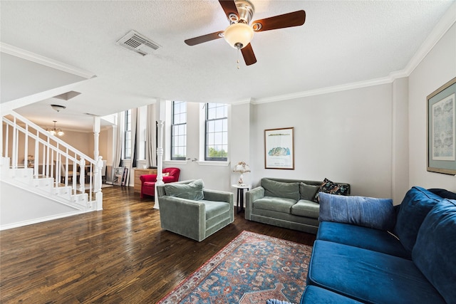 living room with ceiling fan with notable chandelier, dark hardwood / wood-style floors, ornamental molding, a textured ceiling, and ornate columns