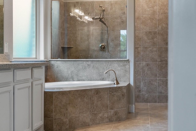 full bath featuring a tile shower, a garden tub, vanity, and tile patterned floors