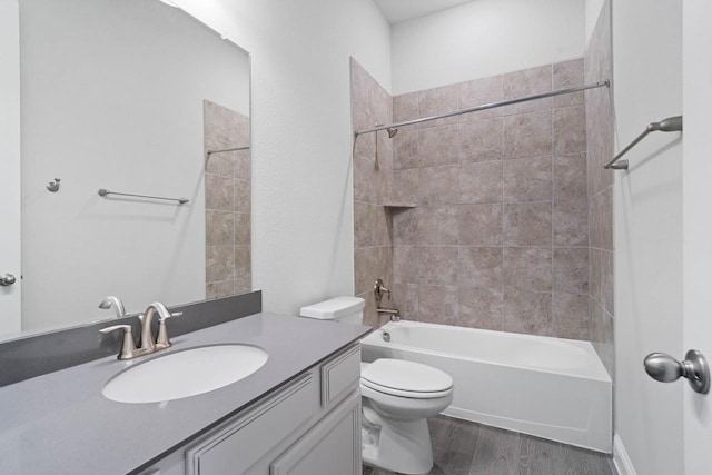 bathroom featuring toilet, shower / tub combination, wood finished floors, and vanity