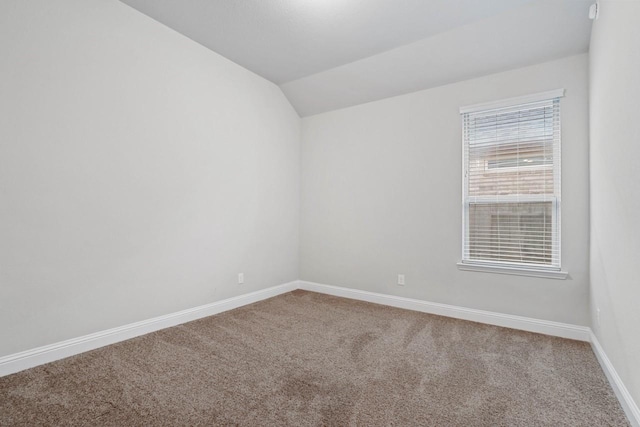 unfurnished room featuring lofted ceiling, carpet floors, and baseboards