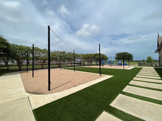 view of home's community featuring playground community, a yard, and fence