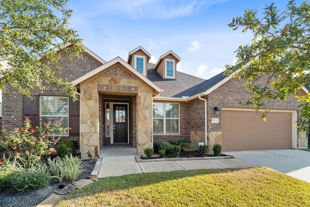 view of front of property featuring a garage, concrete driveway, stone siding, a front lawn, and brick siding