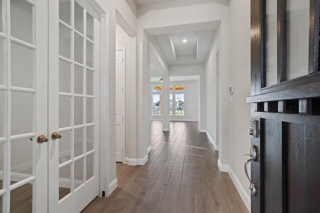 hallway with baseboards, dark wood-type flooring, and french doors