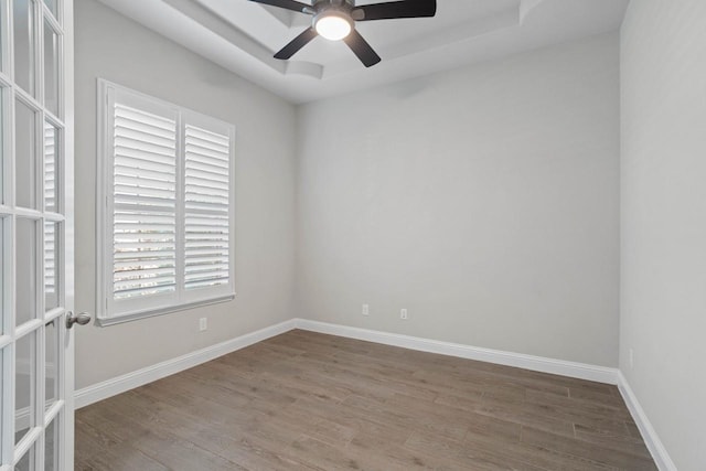 spare room with a ceiling fan, baseboards, wood finished floors, and french doors