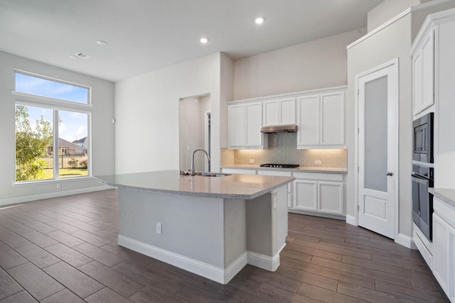 kitchen with gas stovetop, tasteful backsplash, stainless steel microwave, wall oven, and a sink