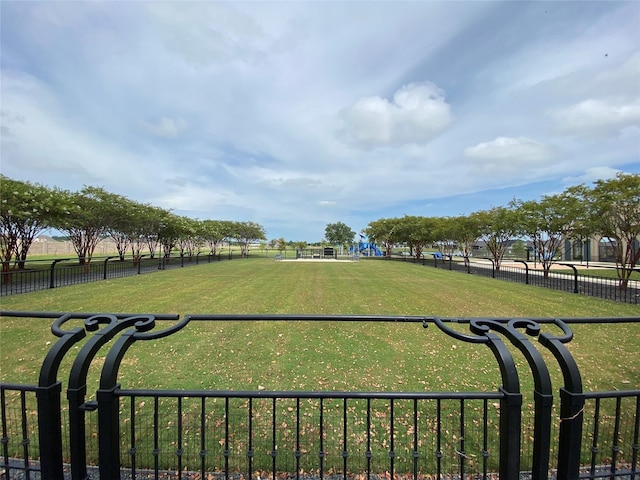 view of community featuring fence and a yard