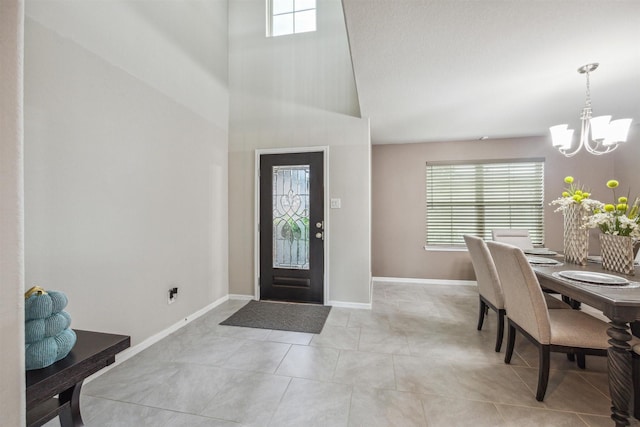 entrance foyer featuring a chandelier, light tile patterned floors, and a towering ceiling