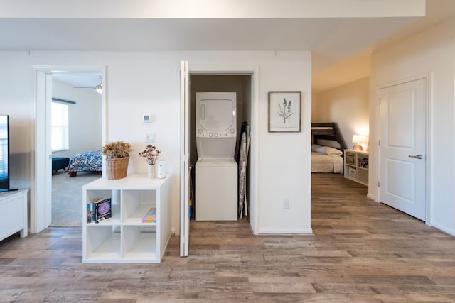 hall with light wood-type flooring and stacked washer and dryer