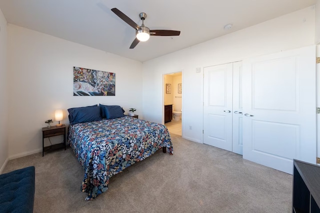 carpeted bedroom with ceiling fan, a closet, and ensuite bathroom