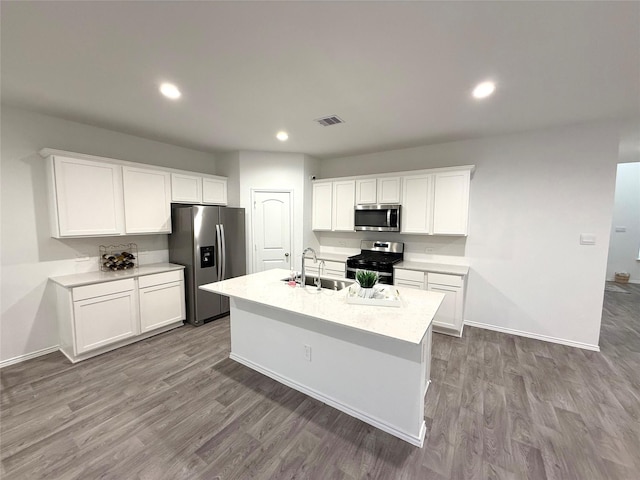 kitchen featuring a center island with sink, white cabinetry, sink, and appliances with stainless steel finishes