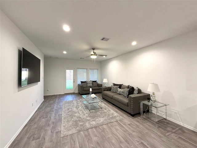 living room featuring hardwood / wood-style floors and ceiling fan