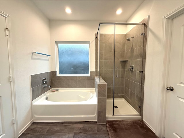 bathroom with hardwood / wood-style floors and separate shower and tub