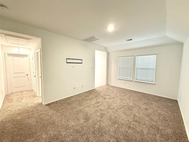 carpeted empty room featuring lofted ceiling