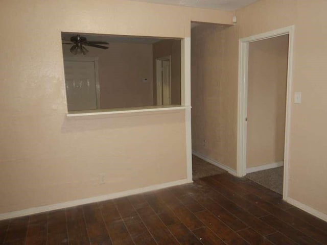 empty room with ceiling fan and dark wood-type flooring