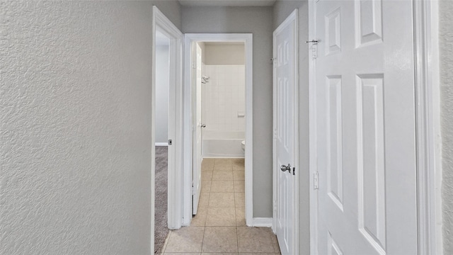 hall featuring light tile patterned floors