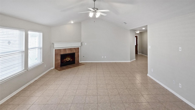 unfurnished living room featuring a tile fireplace, light tile patterned floors, ceiling fan, and lofted ceiling