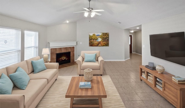 living room featuring ceiling fan, a fireplace, light tile patterned floors, and vaulted ceiling