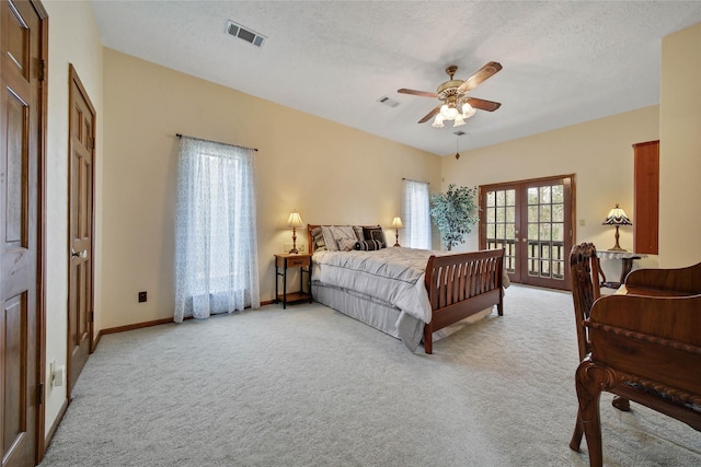 carpeted bedroom with ceiling fan, a textured ceiling, and french doors