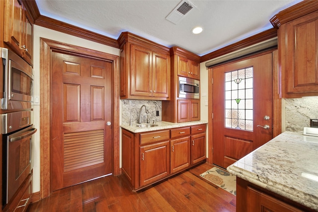 kitchen featuring tasteful backsplash, light stone countertops, sink, and stainless steel appliances