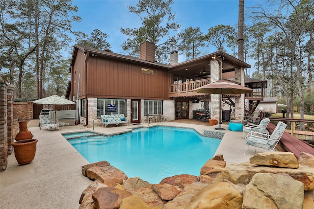 back of property with a balcony, ceiling fan, and a patio area