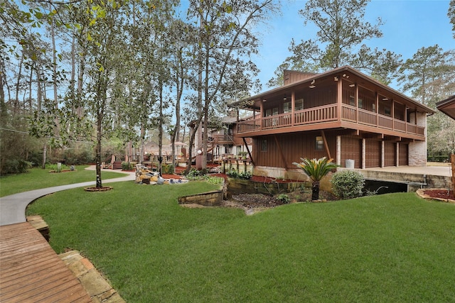 back of property featuring a sunroom, a garage, and a yard