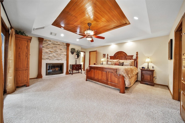 carpeted bedroom featuring a raised ceiling, ceiling fan, a large fireplace, and wood ceiling