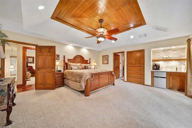 carpeted bedroom with ceiling fan, refrigerator, wooden ceiling, and a tray ceiling