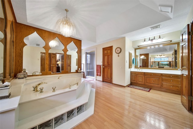 bathroom with hardwood / wood-style floors, a chandelier, vanity, and a tray ceiling