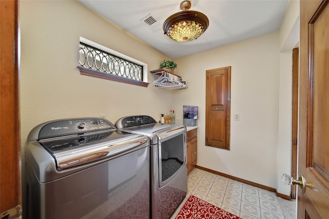 laundry area with washer and dryer and cabinets