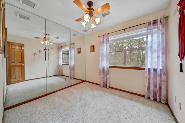 unfurnished bedroom with ceiling fan, light carpet, and a closet