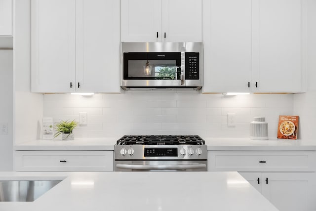 kitchen featuring tasteful backsplash, white cabinetry, and stainless steel appliances