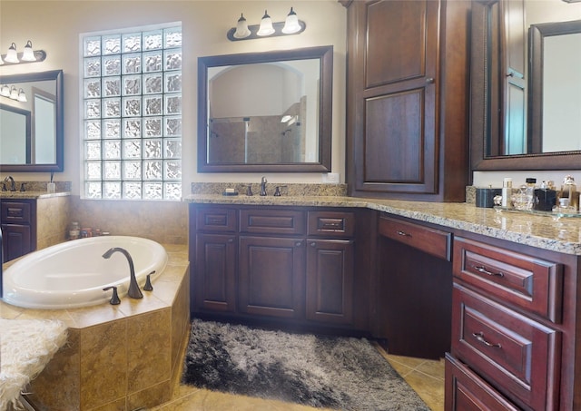 bathroom featuring tile patterned floors, tiled tub, and vanity