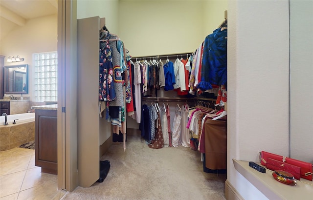 walk in closet featuring light carpet and sink