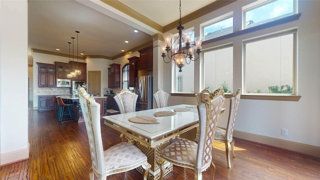 dining room featuring a healthy amount of sunlight, ornamental molding, dark wood-type flooring, and a chandelier