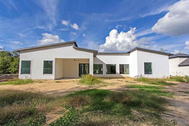 rear view of property with ceiling fan