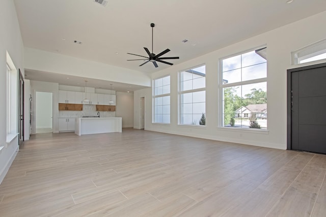 unfurnished living room featuring ceiling fan