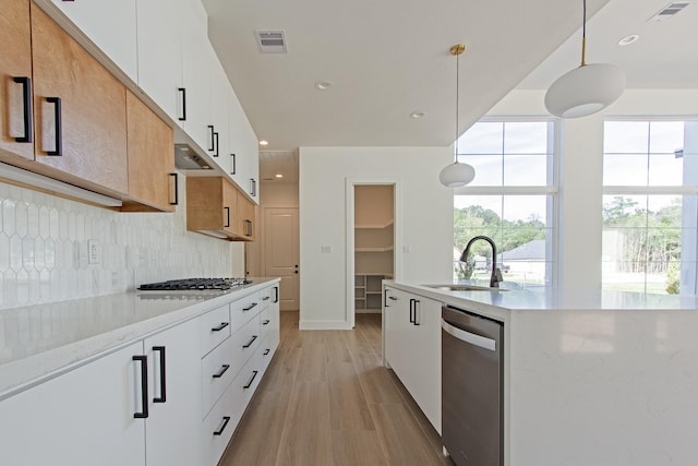 kitchen with white cabinets, decorative light fixtures, and sink