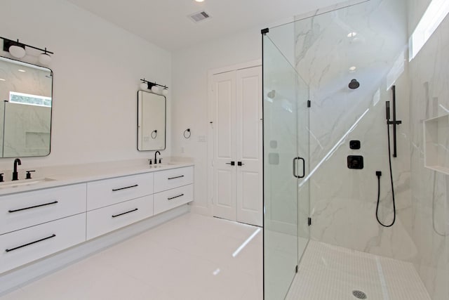 bathroom with a shower with door, vanity, and tile patterned flooring